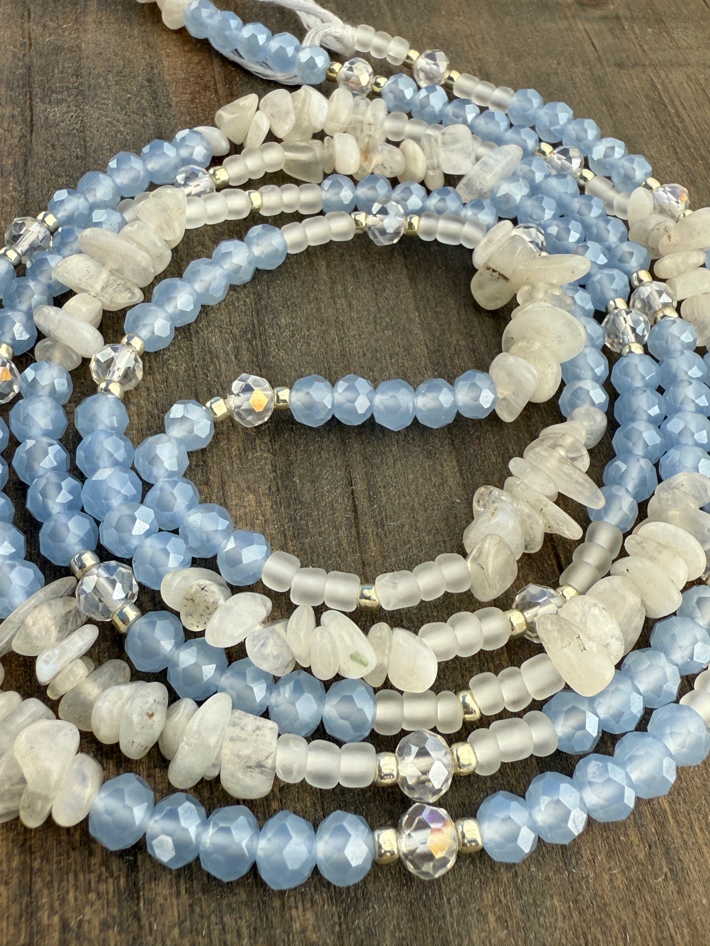 Blue and white waist beads with faceted crystals, frosted glass, and natural moonstone, handmade by Sia Body Beads.