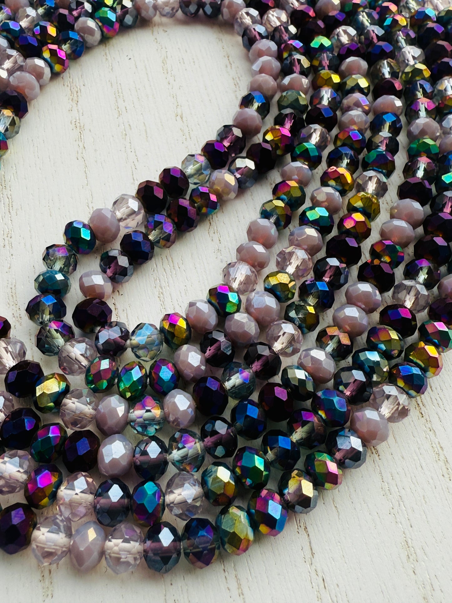 iridescent purple and lavender crystal waist beads arranged in a circular display on a light background