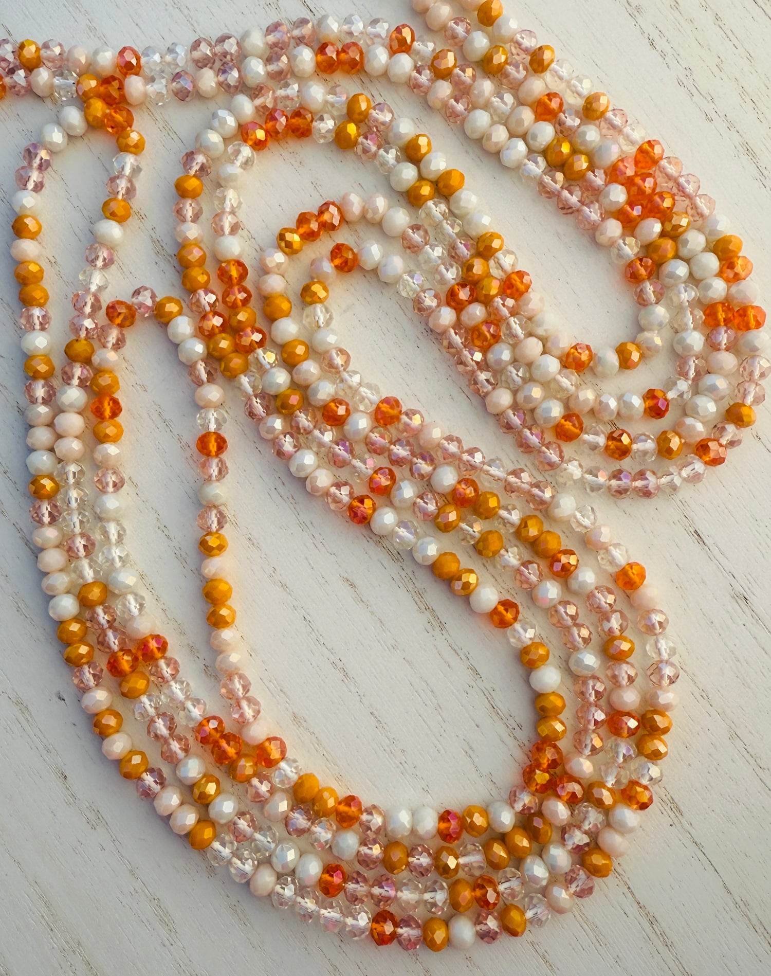 Multicolor orange waist bead on a light wooden surface