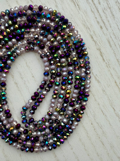 iridescent purple and lavender crystal waist beads arranged in a circular display on a light background
