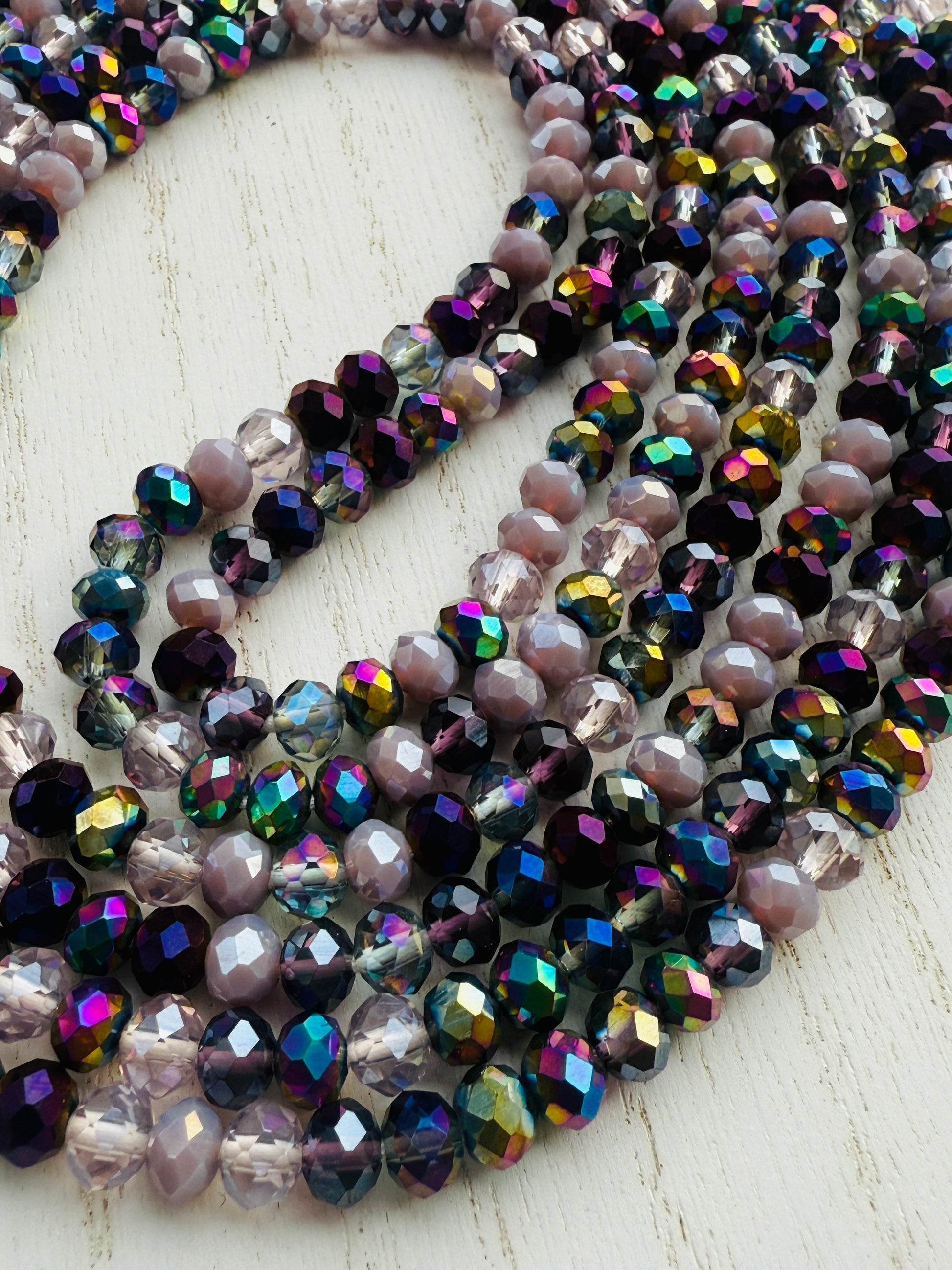 iridescent purple and lavender crystal waist beads arranged in a circular display on a light background