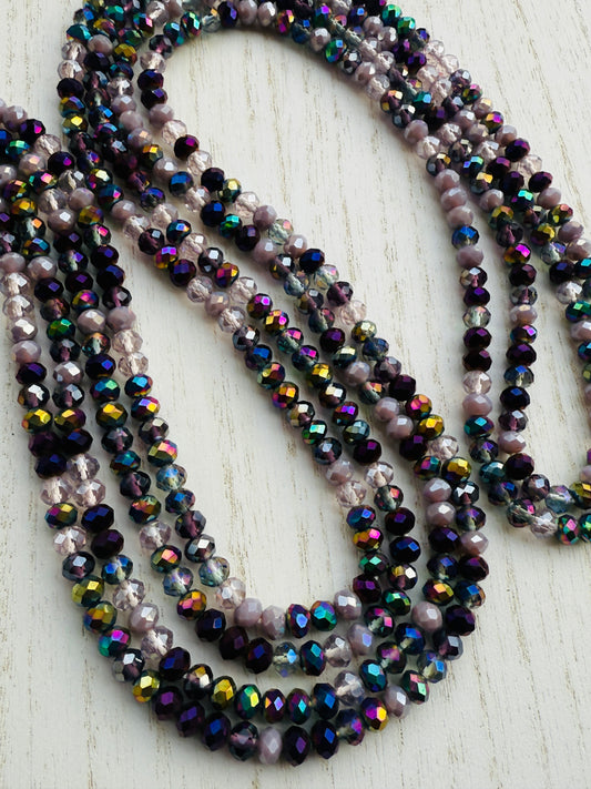 iridescent purple and lavender crystal waist beads arranged in a circular display on a light background