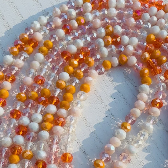 Multicolor orange waist bead on a light wooden surface