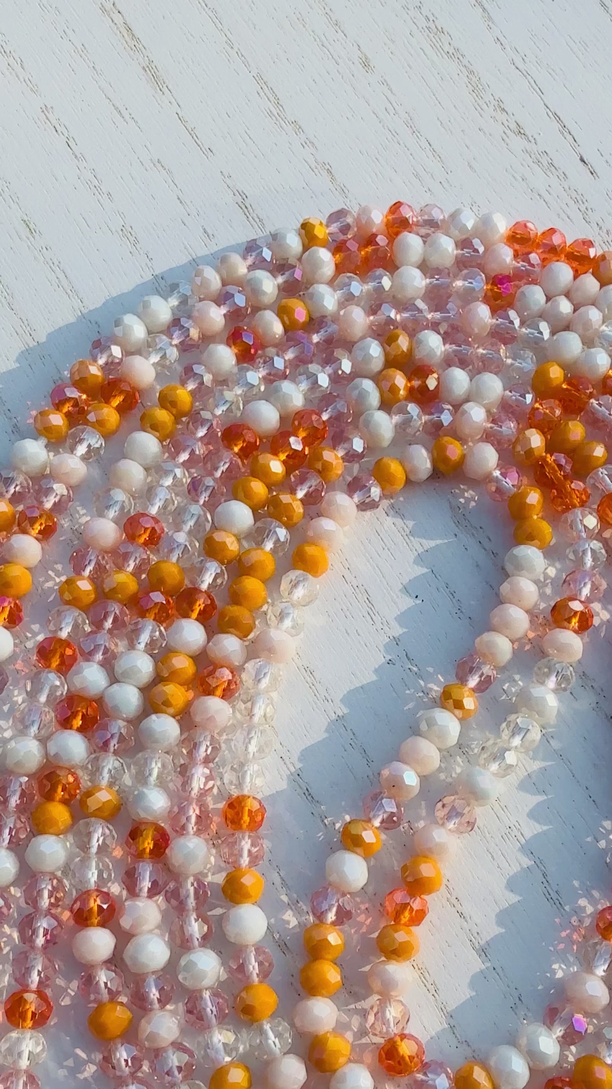 Multicolor orange waist bead on a light wooden surface